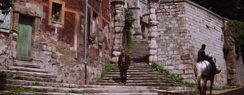 Movie still from “Lust for Life” (1956), directed by George Cukor – A man standing on a set of stairs in a city; Wide shot, Low angle