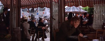 Movie still from “Lust for Life” (1956), directed by George Cukor – A group of people sitting at a table outside; Wide shot, High angle