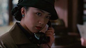 Movie still from “Lust, Caution” (2007), directed by Ang Lee – A woman wearing a hat and holding a phone to her ear; Close Up shot, Low angle