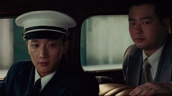 Movie still from “Lust, Caution” (2007), directed by Ang Lee – A man in a uniform sitting next to another man in a car; Close Up shot, Low angle