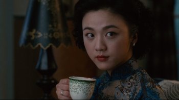 Movie still from “Lust, Caution” (2007), directed by Ang Lee – A woman holding a cup of coffee in her hands; Close Up shot, Over the shoulder angle