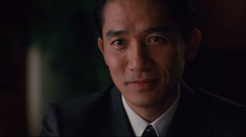 Movie still from “Lust, Caution” (2007), directed by Ang Lee – A person wearing a suit and tie; Close Up shot, Over the shoulder angle