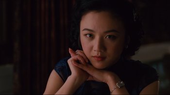 Movie still from “Lust, Caution” (2007), directed by Ang Lee – A woman is sitting with her hands on her chin; Close Up shot, Over the shoulder angle