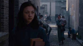 Movie still from “Lust, Caution” (2007), directed by Ang Lee – A woman is holding a book in her hands; Medium shot, Over the shoulder angle