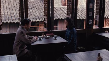 Movie still from “Lust, Caution” (2007), directed by Ang Lee – A man and a woman are sitting at a table; Wide shot, High angle