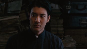 Movie still from “Lust, Caution” (2007), directed by Ang Lee – A man in a black shirt and a black hat; Close Up shot, Over the shoulder angle