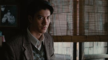 Movie still from “Lust, Caution” (2007), directed by Ang Lee – A man in a suit and tie looking out a window; Close Up shot, Over the shoulder angle