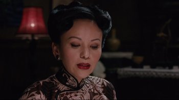 Movie still from “Lust, Caution” (2007), directed by Ang Lee – An asian woman in a floral dress looking down; Close Up shot, Over the shoulder angle