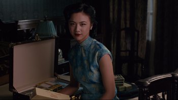 Movie still from “Lust, Caution” (2007), directed by Ang Lee – A woman sitting at a desk in front of papers; Medium shot, Over the shoulder angle