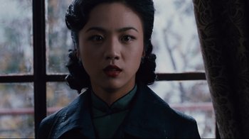 Movie still from “Lust, Caution” (2007), directed by Ang Lee – A young woman with dark curly hair wearing a green jacket; Close Up shot, Low angle