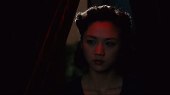 Movie still from “Lust, Caution” (2007), directed by Ang Lee – A young woman with red light shining on her face; Close Up shot, Low angle