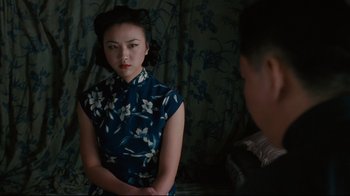 Movie still from “Lust, Caution” (2007), directed by Ang Lee – A woman in a blue dress is looking at a man in a black suit; Medium shot, Over the shoulder angle