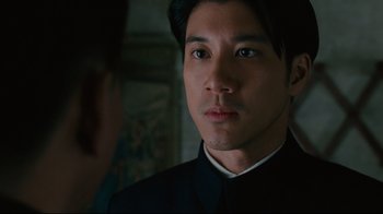 Movie still from “Lust, Caution” (2007), directed by Ang Lee – A man in a black shirt is looking at the camera; Close Up shot, Over the shoulder angle