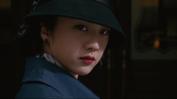 Movie still from “Lust, Caution” (2007), directed by Ang Lee – A woman wearing a black hat and a blue jacket; Close Up shot, Low angle