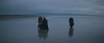 Movie still from “Macbeth” (1971), directed by Roman Polanski – A group of people standing on top of a sandy beach; Extreme Wide shot, High angle