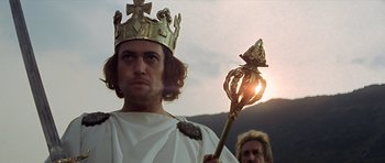 Movie still from “Macbeth” (1971), directed by Roman Polanski – A man wearing a crown and holding a scepter; Close Up shot, Low angle