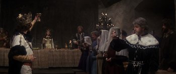 Movie still from “Macbeth” (1971), directed by Roman Polanski – A group of people standing in front of a table with candles on it; Wide shot, Low angle