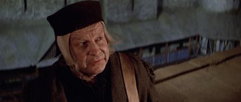 Movie still from “Macbeth” (1971), directed by Roman Polanski – An old man wearing a hat and looking at the camera; Close Up shot, Over the shoulder angle