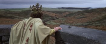 Movie still from “Macbeth” (1971), directed by Roman Polanski – A man wearing a crown standing on top of a hill; Extreme Wide shot, High angle