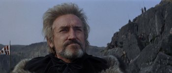 Movie still from “Macbeth” (1971), directed by Roman Polanski – An older man with a beard and a fur coat is looking at the camera; Close Up shot, Low angle