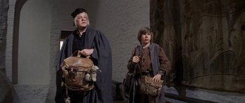 Movie still from “Macbeth” (1971), directed by Roman Polanski – Two men in medieval garb holding bags of money; Medium shot, Low angle