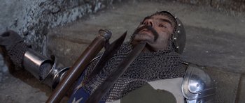 Movie still from “Macbeth” (1971), directed by Roman Polanski – A man in chain mail holding a sword and a knife; Close Up shot, High angle