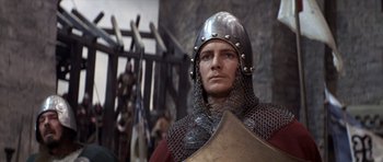 Movie still from “Macbeth” (1971), directed by Roman Polanski – A man wearing a helmet and holding a shield; Close Up shot, Over the shoulder angle