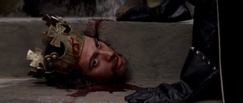 Movie still from “Macbeth” (1971), directed by Roman Polanski – A man with a beard and a crown laying on the ground; Close Up shot, Overhead angle