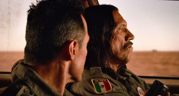 Movie still from “Machete” (2010), directed by Robert Rodriguez – Two men sitting next to each other in a vehicle; Close Up shot, Over the shoulder angle