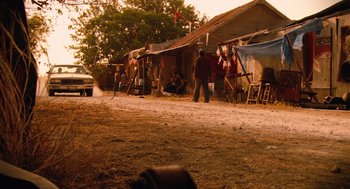 Movie still from “Machete” (2010), directed by Robert Rodriguez – A group of people standing on the side of a road; Wide shot, Over the shoulder angle