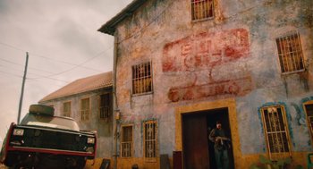 Movie still from “Machete” (2010), directed by Robert Rodriguez – A man standing in front of an old building; Wide shot, Low angle