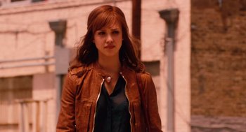 Movie still from “Machete” (2010), directed by Robert Rodriguez – A woman in a brown jacket standing in front of a brick building; Medium shot, Over the shoulder angle