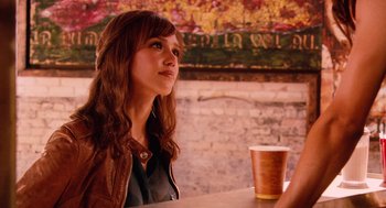 Movie still from “Machete” (2010), directed by Robert Rodriguez – A woman sitting at a table in front of a cup; Medium shot, Over the shoulder angle