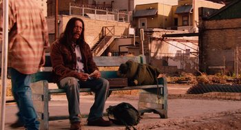 Movie still from “Machete” (2010), directed by Robert Rodriguez – A man sitting on top of a bench next to another man sleeping; Wide shot, Over the shoulder angle