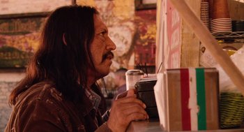 Movie still from “Machete” (2010), directed by Robert Rodriguez – A man sitting at a table with a cup of coffee; Close Up shot, Over the shoulder angle