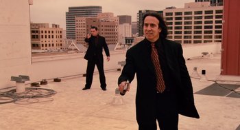 Movie still from “Machete” (2010), directed by Robert Rodriguez – A man in a suit and tie holding a cell phone; Medium shot, Low angle