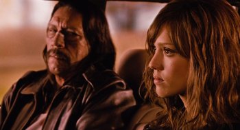 Movie still from “Machete” (2010), directed by Robert Rodriguez – A man and a woman sitting in the back of a car; Close Up shot, Over the shoulder angle