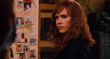 Movie still from “Machete” (2010), directed by Robert Rodriguez – A woman standing in front of a wall covered in pictures; Close Up shot, Over the shoulder angle