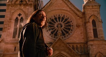 Movie still from “Machete” (2010), directed by Robert Rodriguez – A man standing in front of an old church; Medium shot, Low angle