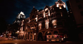 Movie still from “Machete” (2010), directed by Robert Rodriguez – An ambulance parked in front of a large building at night; Extreme Wide shot, Low angle