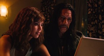 Movie still from “Machete” (2010), directed by Robert Rodriguez – A man and a woman sitting next to each other in a room; Close Up shot, Over the shoulder angle