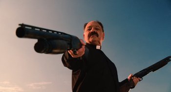 Movie still from “Machete” (2010), directed by Robert Rodriguez – A man in a priest's outfit is holding a gun; Medium shot, Low angle
