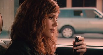 Movie still from “Machete” (2010), directed by Robert Rodriguez – A woman sitting in a car looking at her cell phone; Close Up shot, Over the shoulder angle