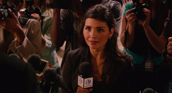Movie still from “Machete” (2010), directed by Robert Rodriguez – A woman is holding a microphone while a group of people watch; Close Up shot, Over the shoulder angle