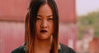 Movie still from “Machete” (2010), directed by Robert Rodriguez – A young asian woman with long black hair; Close Up shot, Low angle