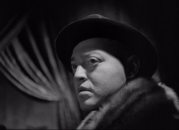 Movie still from “Mad Love” (1935), directed by Karl Freund – A black and white photo of a man wearing a hat; Close Up shot, Low angle