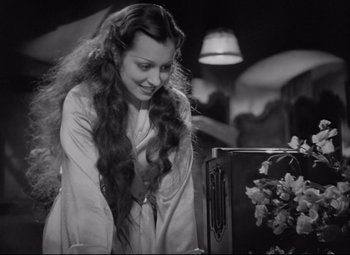 Movie still from “Mad Love” (1935), directed by Karl Freund – A woman with long hair standing in front of a suitcase; Medium shot, High angle