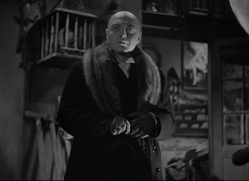 Movie still from “Mad Love” (1935), directed by Karl Freund – A bald man in a coat and a fur collar; Medium shot, Low angle