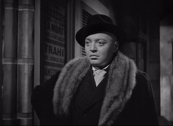Movie still from “Mad Love” (1935), directed by Karl Freund – A man wearing a hat and a fur collar; Medium shot, Over the shoulder angle