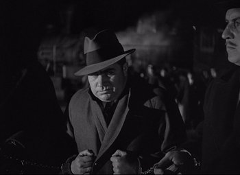 Movie still from “Mad Love” (1935), directed by Karl Freund – A man wearing a suit and a hat; Medium shot, Low angle